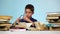 Boy wears glasses and leafing through the book. Blue background. Slow motion