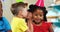 Boy whispering to girl while sitting with friends during birthday party 4k