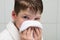 Boy, in a white bathrobe, in the bathroom, wipes his face with a towel, after washing, close-up