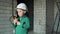 a boy in a white helmet, is playing inspector at a construction site