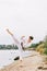 Boy in a white kimono with brown belt on a natural background. Intense karate exercise concept. Copy space.