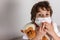 Boy in white tshirt and protective white medical mask afraid with toys monkey on white background. Fight with Coronavirus epidemic