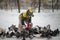 boy in winter warm clothes feeds pigeons in city park. Pigeons in snow. Rescue birds in winter from hunger. Care for wild animals