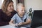 Boy working on a computer together with his mom at home. E-lessons, education for kids.