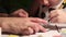 Boy works on his art project painting with a brush with his mother\'s help