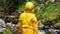 Boy in yellow coat watches the river