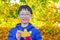 Boy with yellow leave in autumn park