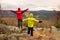 Boy in yellow and man in red warm jacket stand on a rock in a cold windy spring day. Active lifestyle, outdoor activities