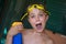 Boy with Yellow Pool Goggles Plays with Solar Sunscreen Bottle