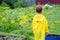 A boy in a yellow raincoat walks in the rain, back view. A child on the street. Bright clothes.