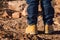 Boy in yellow shoes standing in desert