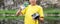 A boy in a yellow T-shirt holds a camera in his hand without a lens and a sponge with soap. Crazy cleaning photographic equipment