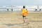 A boy in a yellow towel walks on the sandy Mackenzie beach in Larnaca in the autumn windy weather. Cyprus