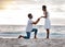 Boyfriend asking his girlfriend to marry him while standing on the beach together. African american man proposing to his