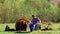 Boyfriend sitting on camping seat while girlfriend preparing the tent