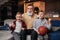 Boys on couch with their grandfather cheering for a basketball game and holding a basketball ball. Huge sports fanats.