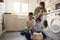 Boys doing laundry with father watching