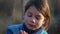 The boys face closeup with bread in his hands. Hungry boy eating white bread.