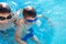 Boys holding breath under water in swimming pool