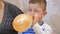 Boys inflate balloons, emotions fear closeup,in profile