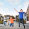 Boys jumping on street. School holidays