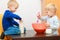 Boys kids baking cake. Children beating dough with wire whisk.