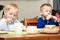 Boys kids children eating corn flakes breakfast meal at the table