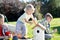 Boys make a birdhouse for the birds in the garden of a summer sunny day