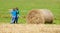 Boys Moving Bale of Hay with Stick as a Lever