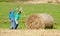 Boys Moving Bale of Hay with Stick as a Lever