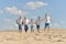 Boys with parents running on sand