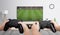 Boys play soccer on the gaming console on a large TV in the room