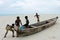 Boys playing near a boat on the seashore