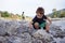 Boys playing and throwing rocks at the river