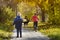 Boys running towards her mother. Autumn Park. Back view