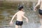 Boys running on the water splashing water drops concept camping