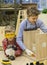 boys with screwdrivers repairing wooden stool