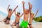 Boys sit on the beach in scuba masks lift hands