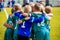 Boys` sports team huddling. Children playing sports in a team. Team sports for kids. Children sports football soccer team