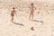 Boys teenagers playing soccer on the beach