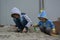 Boys of two and seven years old play in the sandbox.