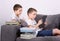 Boys using a tablet PC on the sofa.