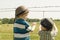 Boys watching cows in a field