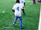 Boys in white and blue football sport form make exercises on green field. Football for children, active lifestyle. Training