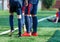 Boys in white and blue sportswear plays football on field, dribbles ball. Young soccer players with ball on green grass. Training