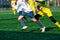 Boys at white yellow sportswear run, dribble, attack on football field. Young Soccer players with ball on green grass. Training