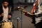 A boysband of guitarist, bassist, and drummer rehearse in their garage.