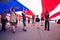 Boyscouts and Cubscouts walk underneath US Flag