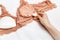 Bra with additional inserts for visual breast augmentation. Beige brassiere Push-up on white background