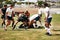 Brace yourself, rugby can be brutal. a group of young men playing a game of rugby.